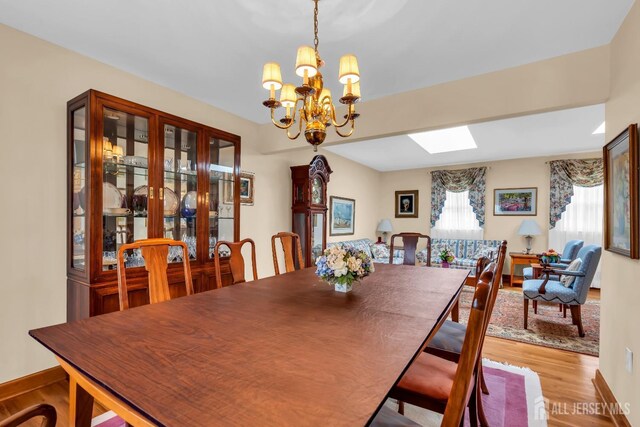 423 Brentwood Dr, Piscataway, NJ 08854 - dining space with a chandelier, light wood finished floors, and a skylight