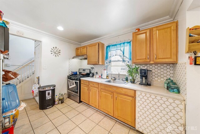 kitchen featuring light tile patterned flooring, sink, tasteful backsplash, ornamental molding, and stainless steel range with gas cooktop