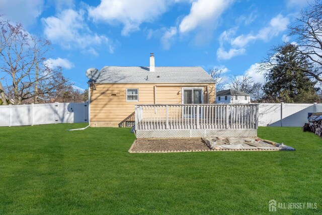 rear view of house with a yard and a wooden deck