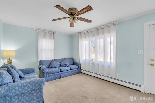 carpeted living room with ceiling fan, a baseboard radiator, and a wealth of natural light