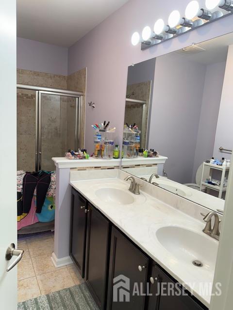 437 NE Micali Way S, Plainfield, NJ 07080 - full bathroom featuring tile patterned floors, double vanity, and a shower stall