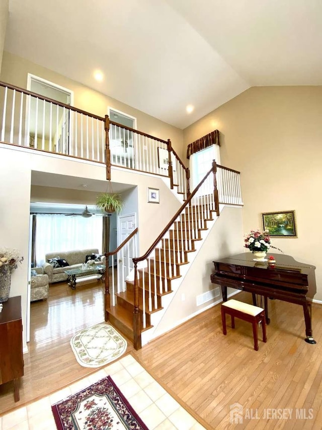 57 Yorktown Rd, South Brunswick, NJ 08852 - stairs featuring healthy amount of natural light, wood finished floors, and high vaulted ceiling
