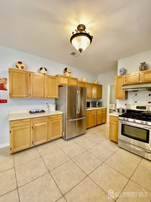 57 Yorktown Rd, South Brunswick, NJ 08852 - kitchen featuring appliances with stainless steel finishes, under cabinet range hood, light countertops, and light tile patterned floors