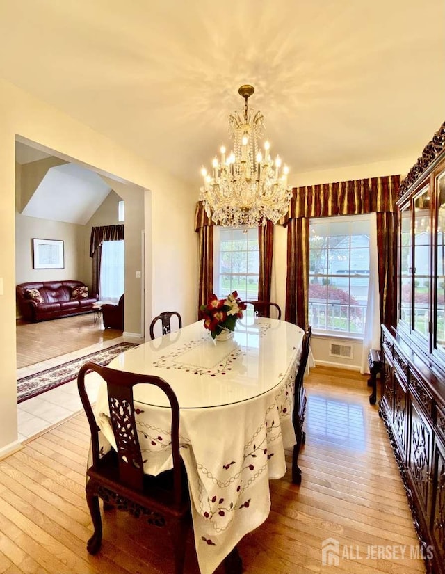 57 Yorktown Rd, South Brunswick, NJ 08852 - dining area with hardwood / wood-style flooring, a chandelier, and vaulted ceiling
