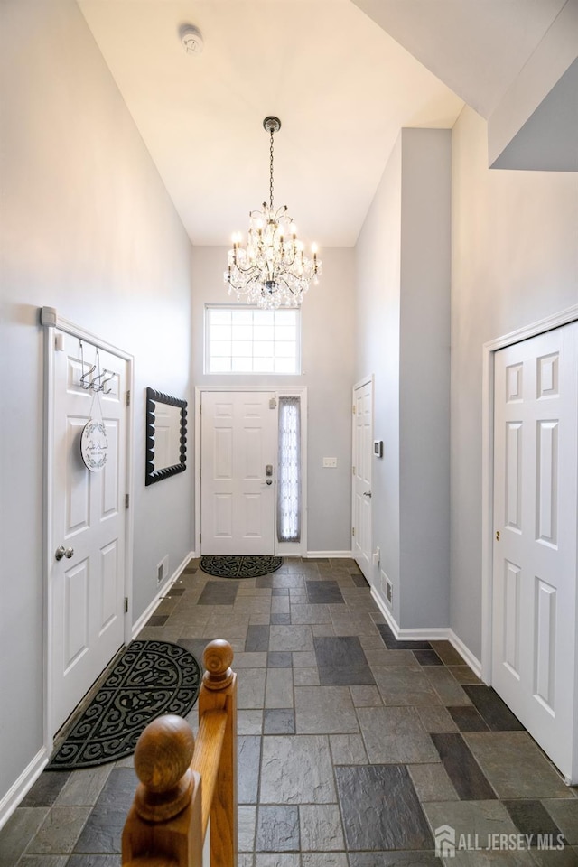 4 Linda Ct, Old Bridge, NJ 08879 - foyer entrance with high vaulted ceiling, stone tile floors, and a chandelier