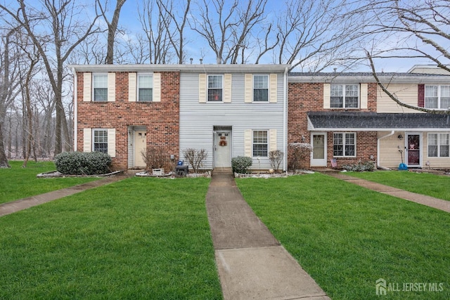 view of property with a front lawn and brick siding