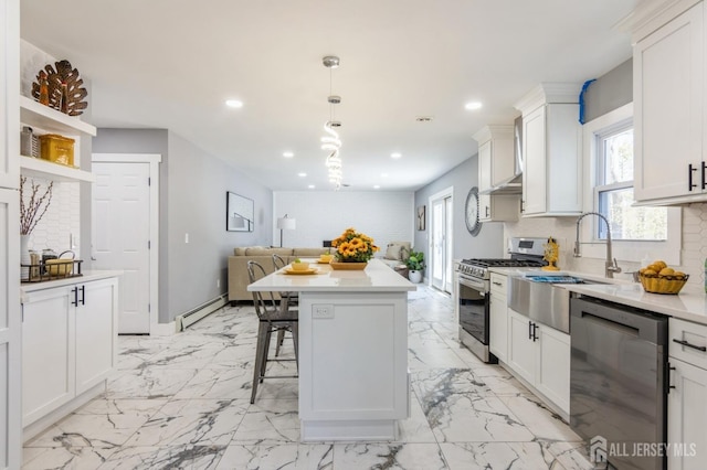 kitchen featuring backsplash, appliances with stainless steel finishes, a sink, a baseboard heating unit, and recessed lighting