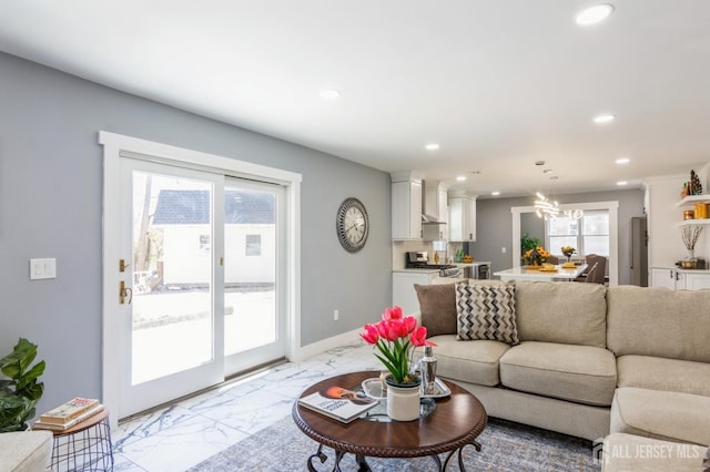 living area featuring recessed lighting, marble finish floor, baseboards, and an inviting chandelier