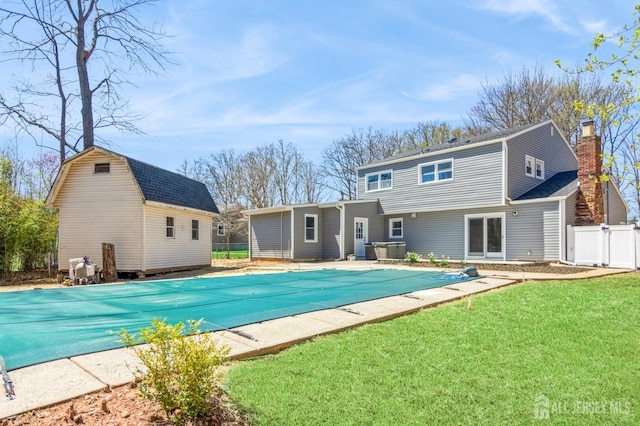 view of pool with fence, a yard, and a covered pool