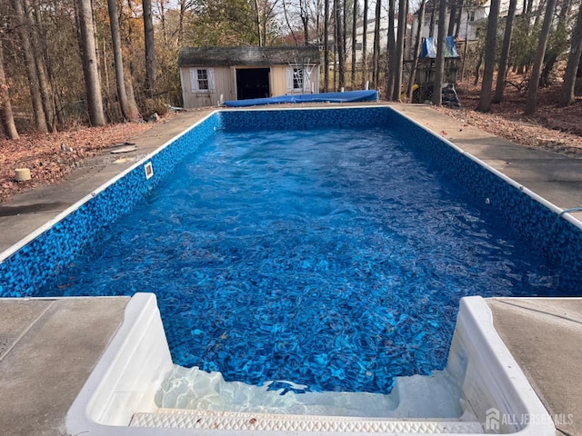 view of pool with an outdoor structure and a covered pool