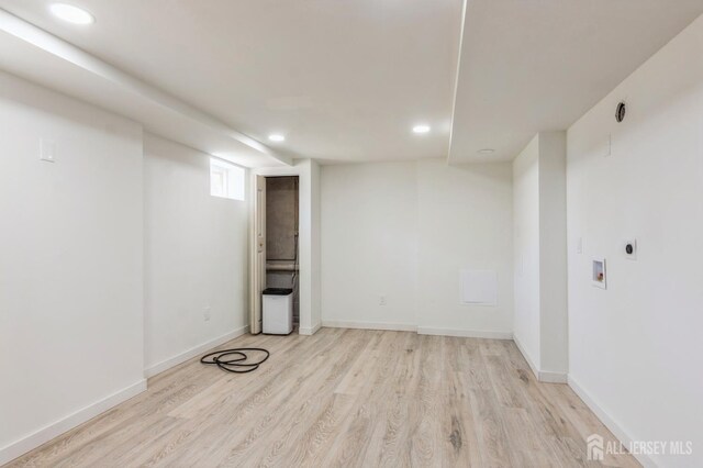below grade area featuring light wood-style floors, recessed lighting, and baseboards