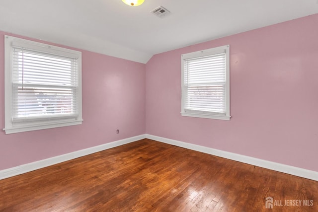 spare room with lofted ceiling and hardwood / wood-style floors