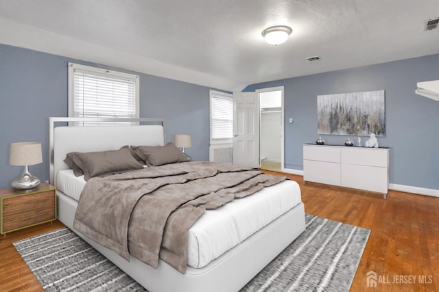 bedroom with vaulted ceiling and wood-type flooring