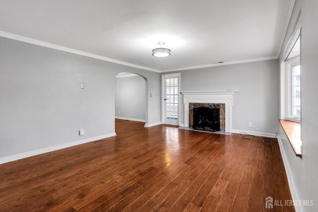 unfurnished living room with a premium fireplace, crown molding, and dark hardwood / wood-style floors