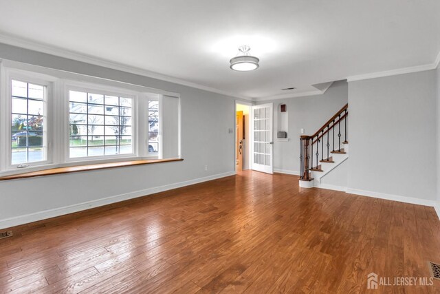 empty room featuring wood-type flooring and ornamental molding