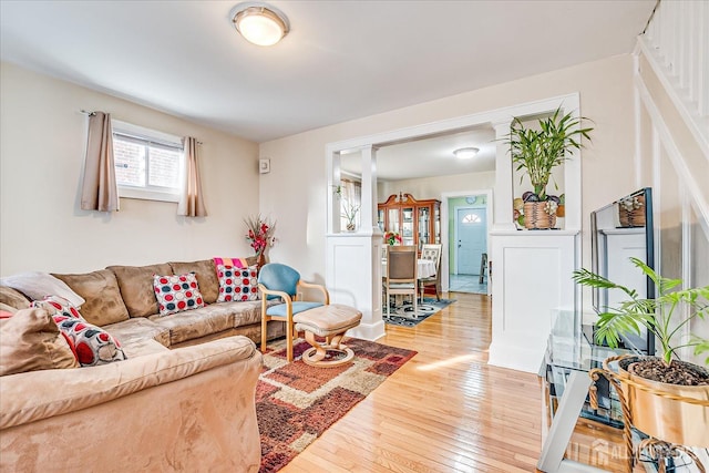 living room with wood-type flooring and ornate columns