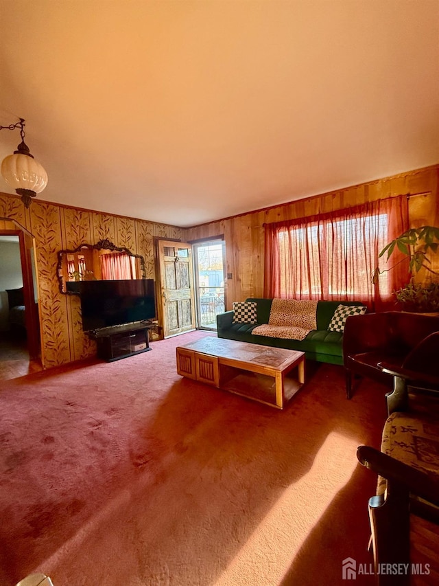 carpeted living area with wooden walls