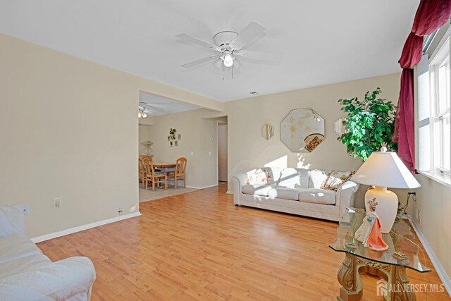 living room with light hardwood / wood-style floors and ceiling fan