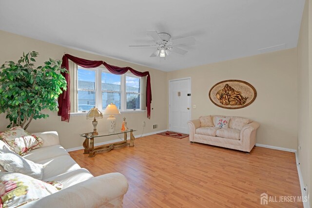 living room featuring ceiling fan and light wood-type flooring