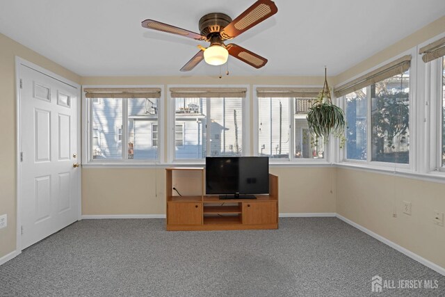 unfurnished sunroom with ceiling fan