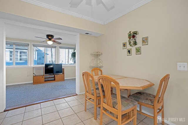 tiled dining room featuring ornamental molding and ceiling fan