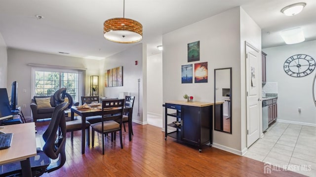 dining room featuring light wood-type flooring, visible vents, and baseboards