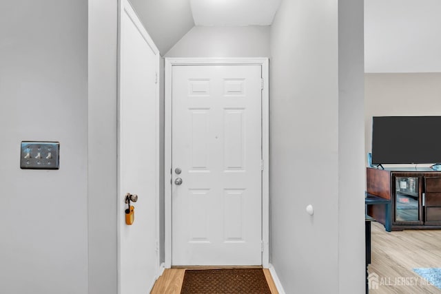 doorway featuring light wood-style floors and baseboards