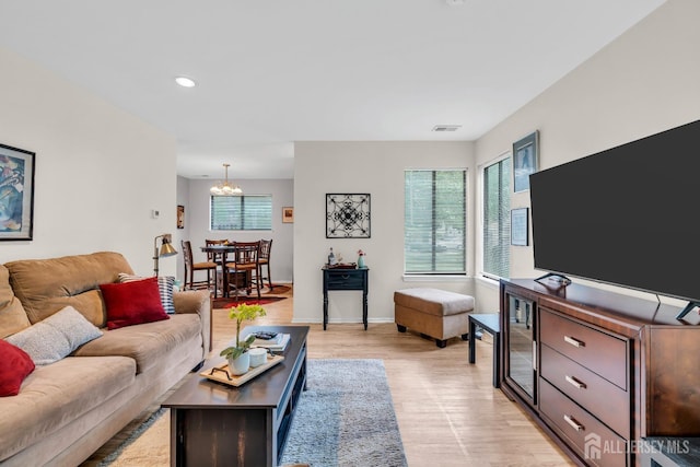 living room with an inviting chandelier, visible vents, baseboards, light wood-style floors, and recessed lighting