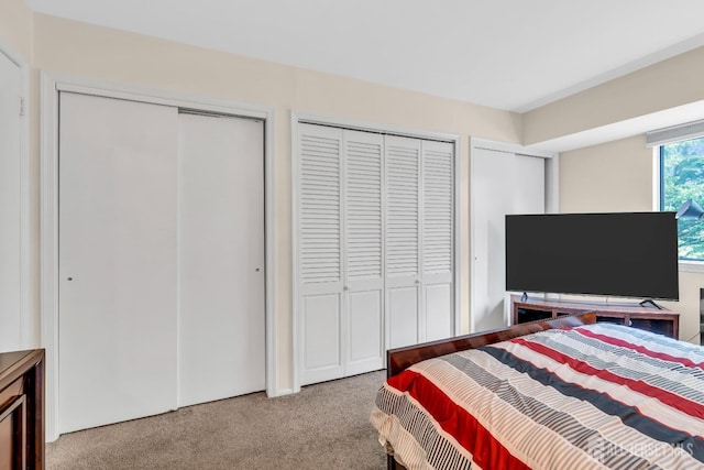 carpeted bedroom featuring multiple closets