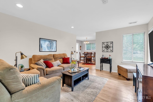 living room featuring light wood-style flooring, visible vents, baseboards, a chandelier, and recessed lighting