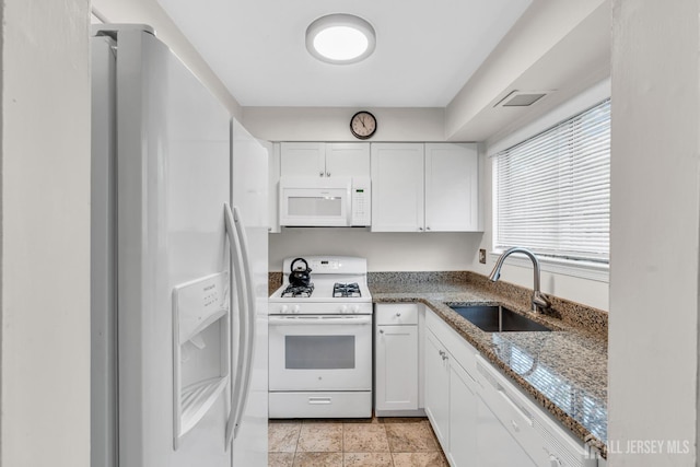 kitchen featuring white appliances, a sink, white cabinets, and stone counters