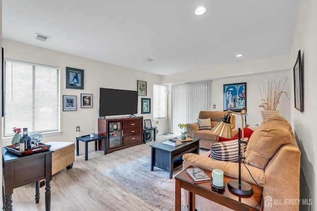 living area with baseboards, recessed lighting, light wood finished floors, and visible vents