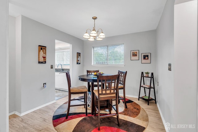 dining room with baseboards, a chandelier, and light wood-type flooring