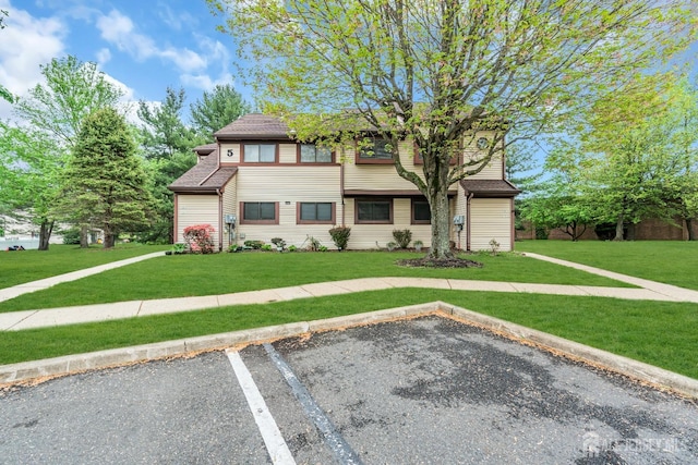 view of front of property with a front lawn and uncovered parking