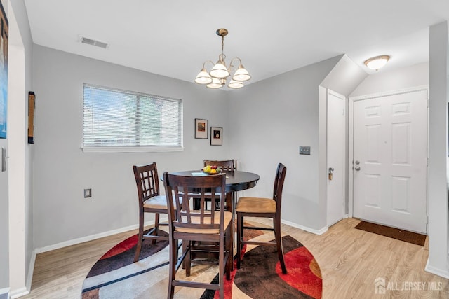 dining space with light wood-style floors, visible vents, baseboards, and a notable chandelier