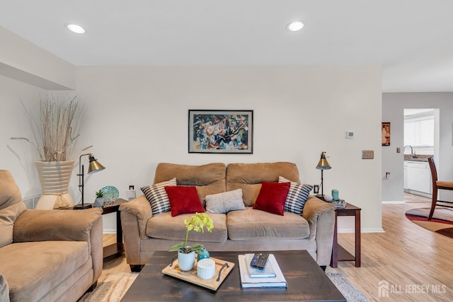 living room featuring light wood finished floors, baseboards, and recessed lighting