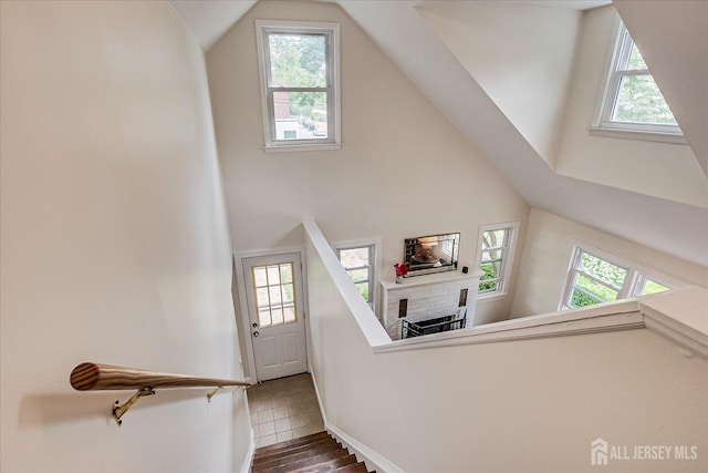 61 Thomas St, Metuchen, NJ 08840 - staircase featuring healthy amount of natural light, high vaulted ceiling, wood finished floors, baseboards, and a fireplace