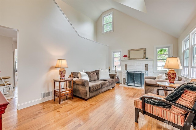 61 Thomas St, Metuchen, NJ 08840 - living room featuring high vaulted ceiling, light wood-style flooring, a brick fireplace, and healthy amount of natural light