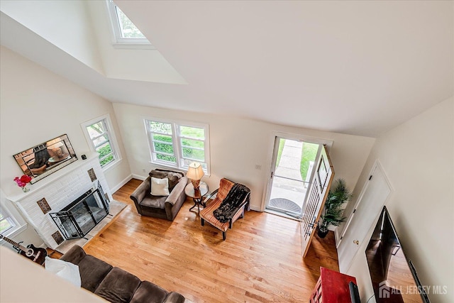 61 Thomas St, Metuchen, NJ 08840 - living room featuring healthy amount of natural light, light wood-type flooring, vaulted ceiling, a fireplace, and a skylight