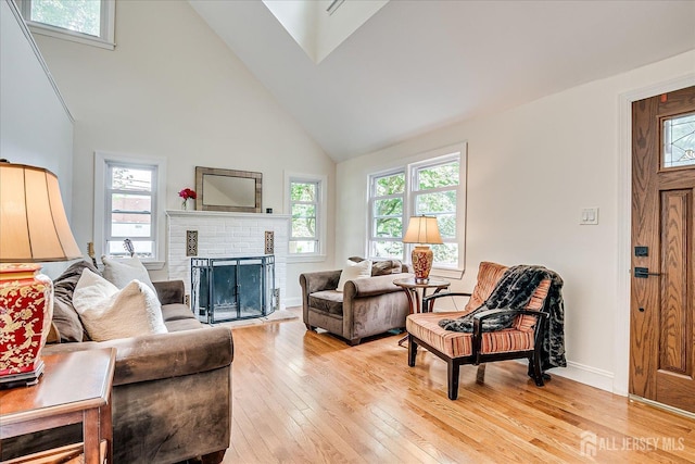 61 Thomas St, Metuchen, NJ 08840 - living area featuring high vaulted ceiling, light wood finished floors, a fireplace, and baseboards