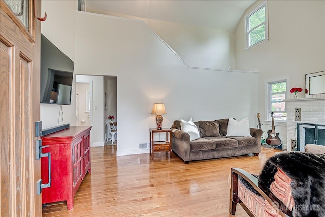 61 Thomas St, Metuchen, NJ 08840 - living room with high vaulted ceiling, light wood-style floors, a fireplace, and baseboards