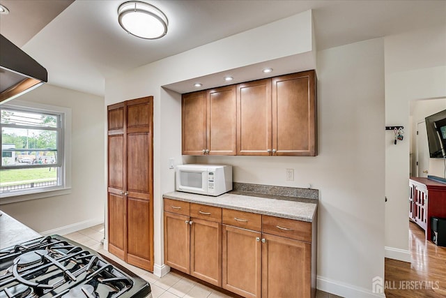 61 Thomas St, Metuchen, NJ 08840 - kitchen featuring white microwave, baseboards, range, brown cabinets, and light countertops