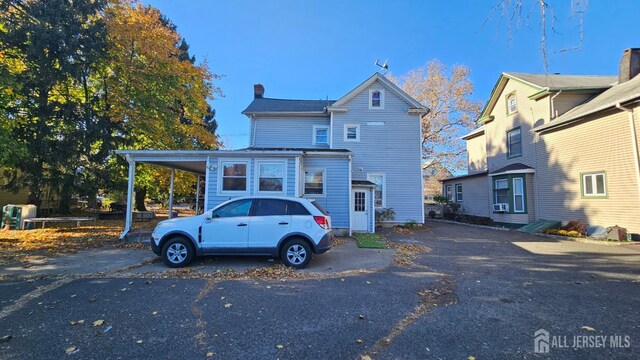 view of front facade with cooling unit and a carport