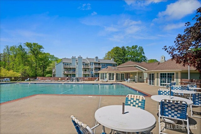 pool with fence and a patio area