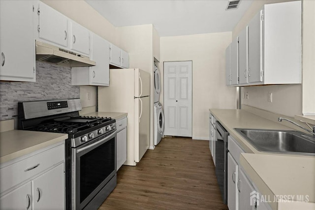 5151 Beech Ct, South Brunswick, NJ 08852 - kitchen with appliances with stainless steel finishes, stacked washing machine and dryer, under cabinet range hood, a sink, and tasteful backsplash