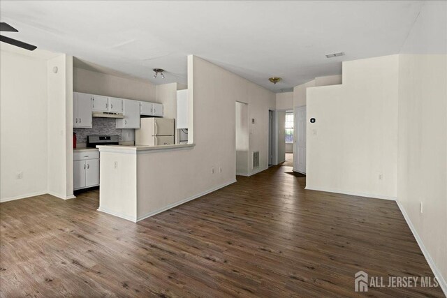 kitchen featuring ceiling fan, visible vents, freestanding refrigerator, under cabinet range hood, and dark wood-type flooring