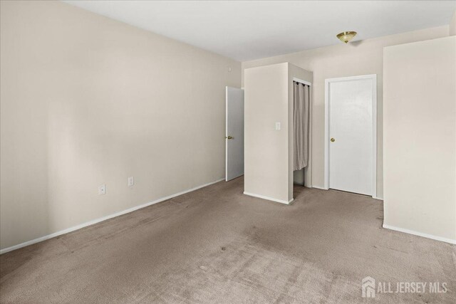 unfurnished bedroom featuring carpet flooring and baseboards