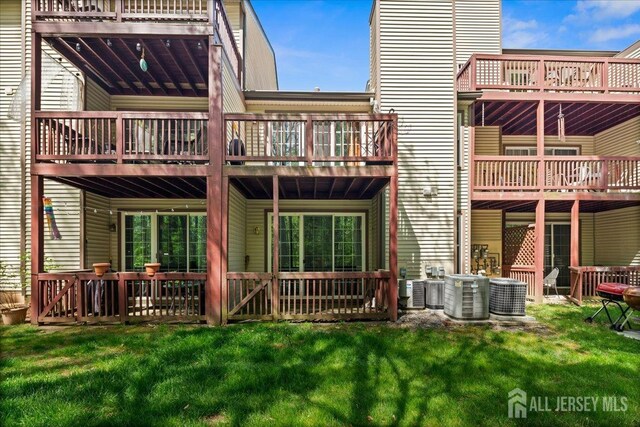 back of house featuring a yard and central AC unit