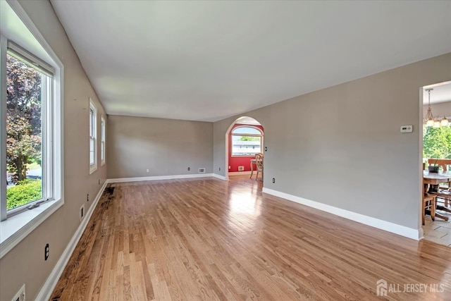 7 Mill Rd, Jamesburg, NJ 08831 - spare room featuring arched walkways, plenty of natural light, light wood-style floors, and baseboards
