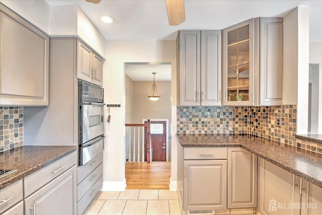 7 Mill Rd, Jamesburg, NJ 08831 - kitchen featuring a warming drawer, stainless steel oven, light tile patterned floors, glass insert cabinets, and tasteful backsplash